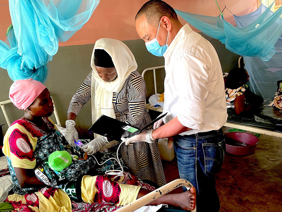 Medical staff capturing the fingerprints of the newborn baby using a device connected to a computer.