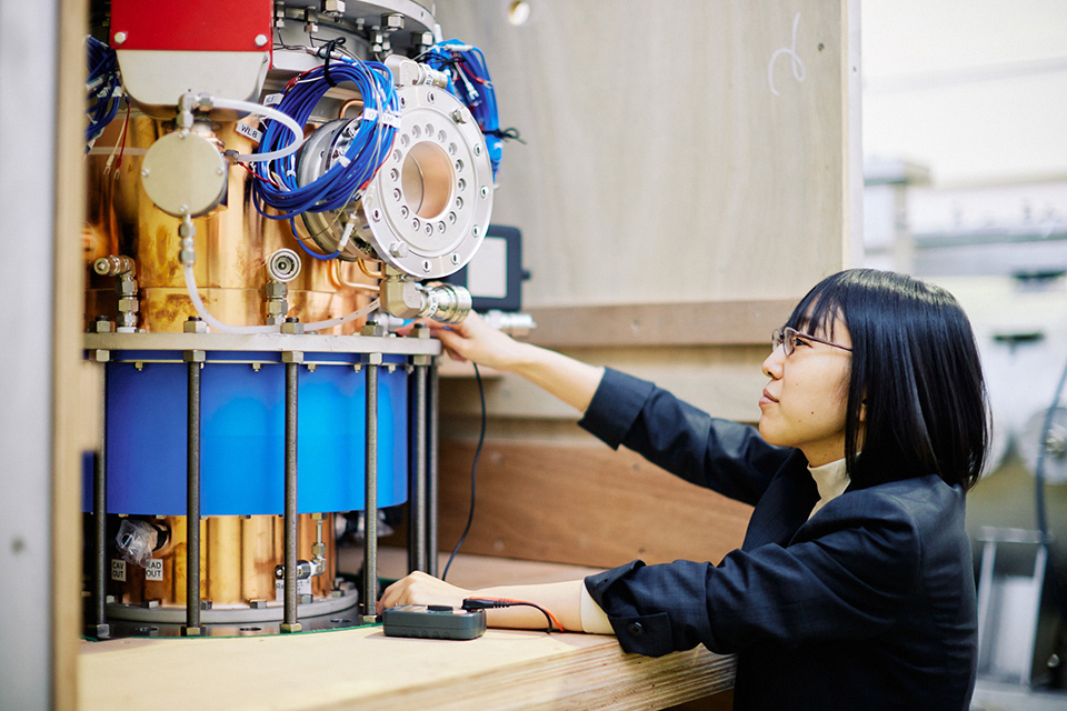 Laboratory equipment with gold pipes and light blue cords and more being operated by a staff member.