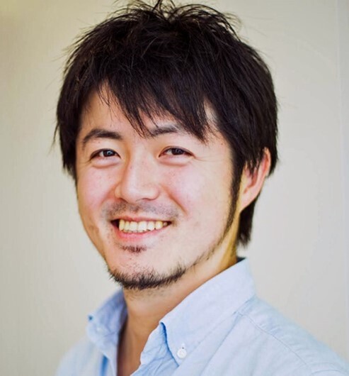 Portrait of a Japanese journalist Furuta Daisuke, white wall in a background.
