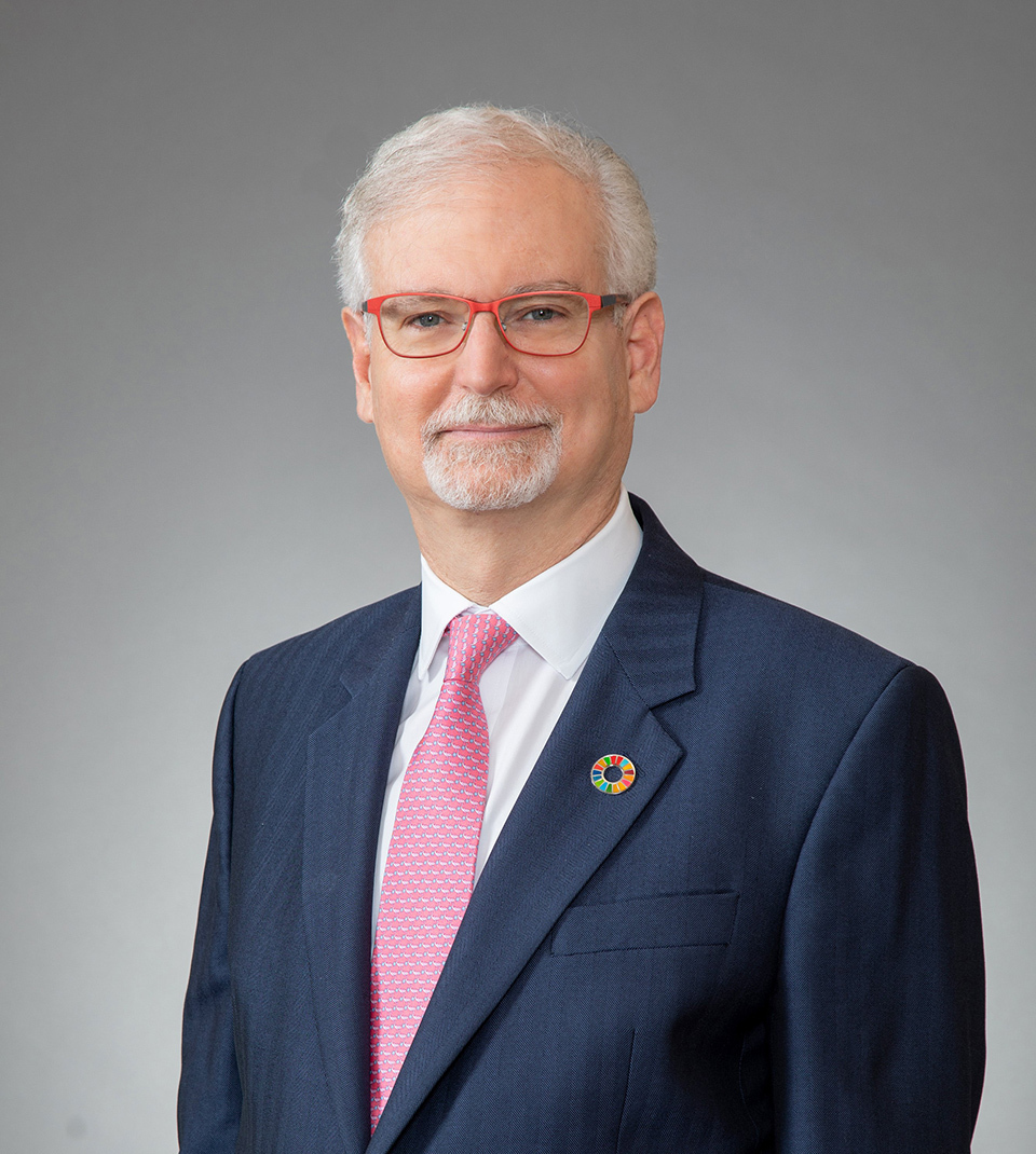 David Semaya, executive chairman of Sumitomo Mitsui Trust Asset Management, in a dark blue textured blazer with a white shirt and a pink tie.