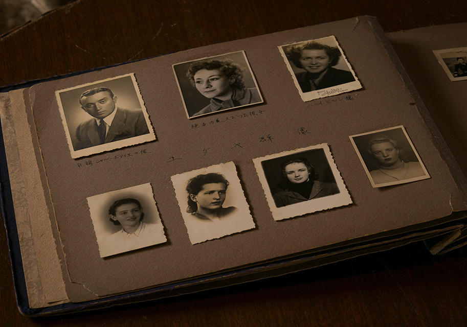 The Osako Album, an age-old open photo album containing eight black-and-white photographs.