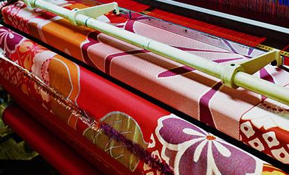 Large fabric rolls are neatly rolled up, showcasing their vibrant Japanese Nishijin pattern, texture and color.