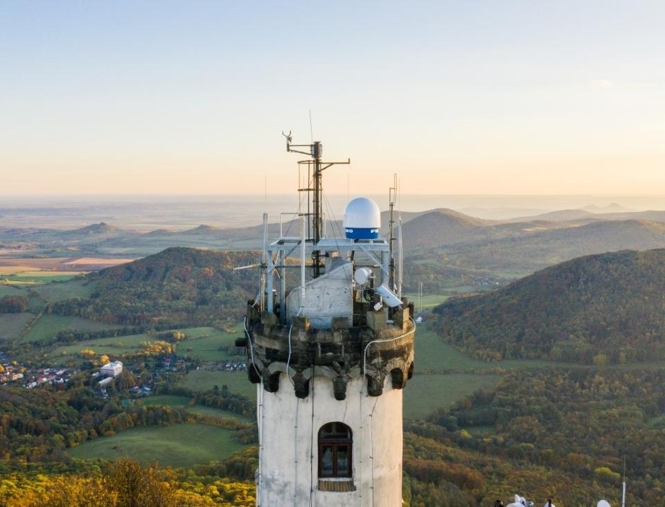 Photo of a weather radar on top of an observatory in the Czech Republic, overlooking countryside