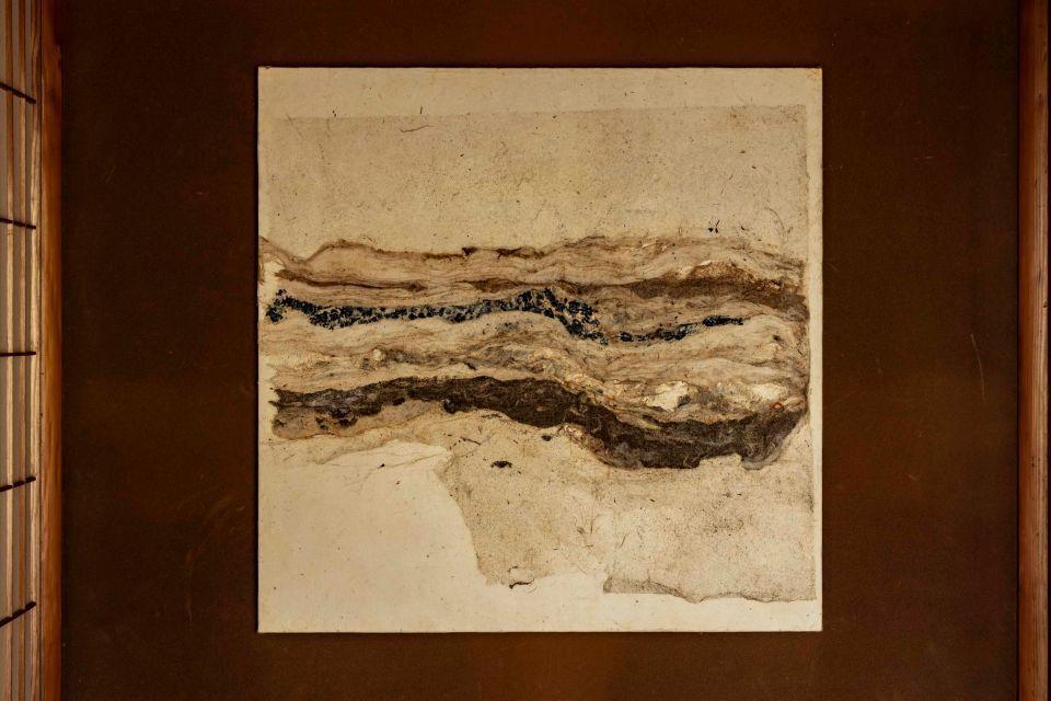 A large piece of art on a dark wall, made from washi paper