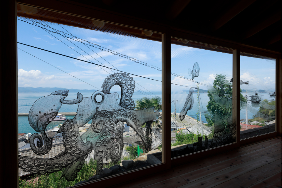 Large widows overlooking the ocean that are painted with fantastical scenes and creatures