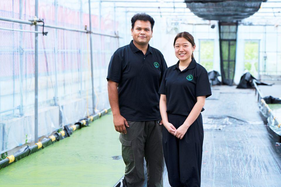 CEO Kitamura Moana and CTO Sajjad Kamal Shuvro posing in front of a large vat of wolffia