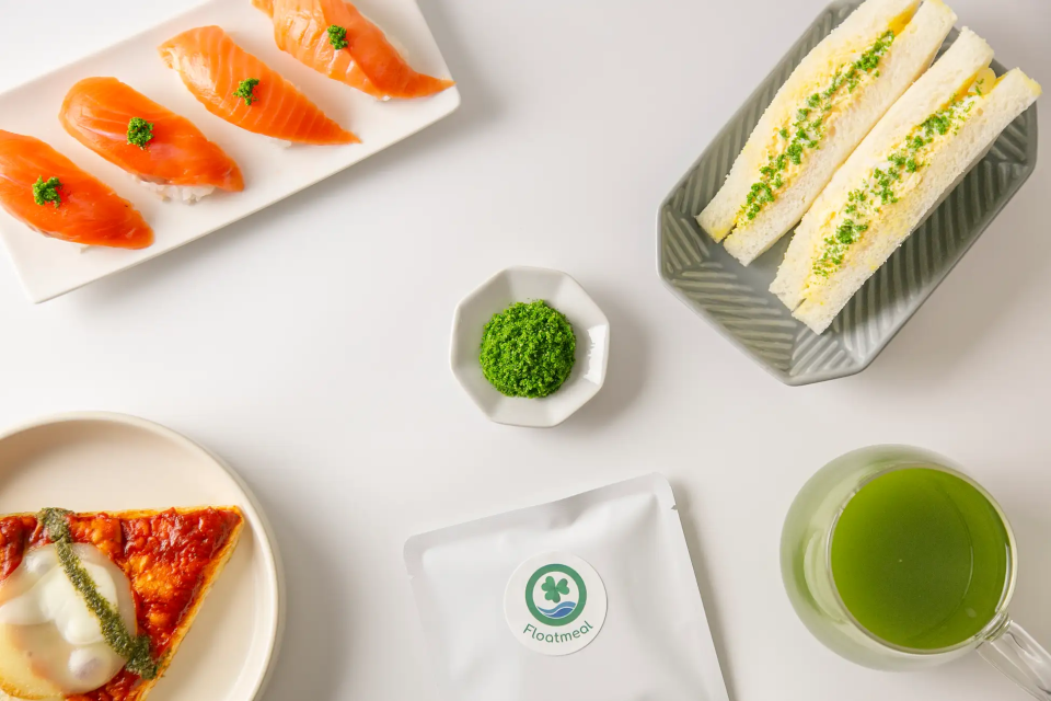 An array of foods made with the addition of wolffia, inculding egg sandwiches, a green drink, sushi and pizza