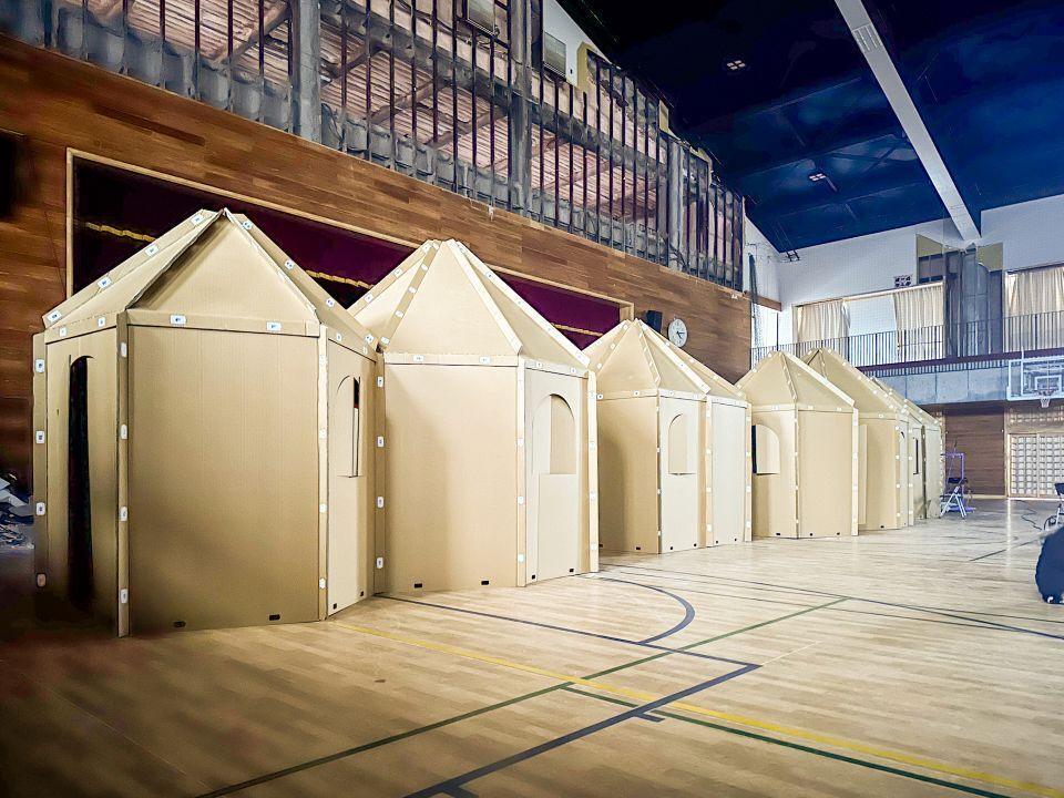 Indoor versions of the Instant House made from cardboard inside a school gym
