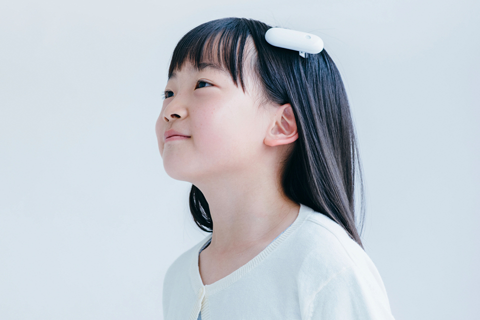 A young girl wearing the Ontenna attached to her hair