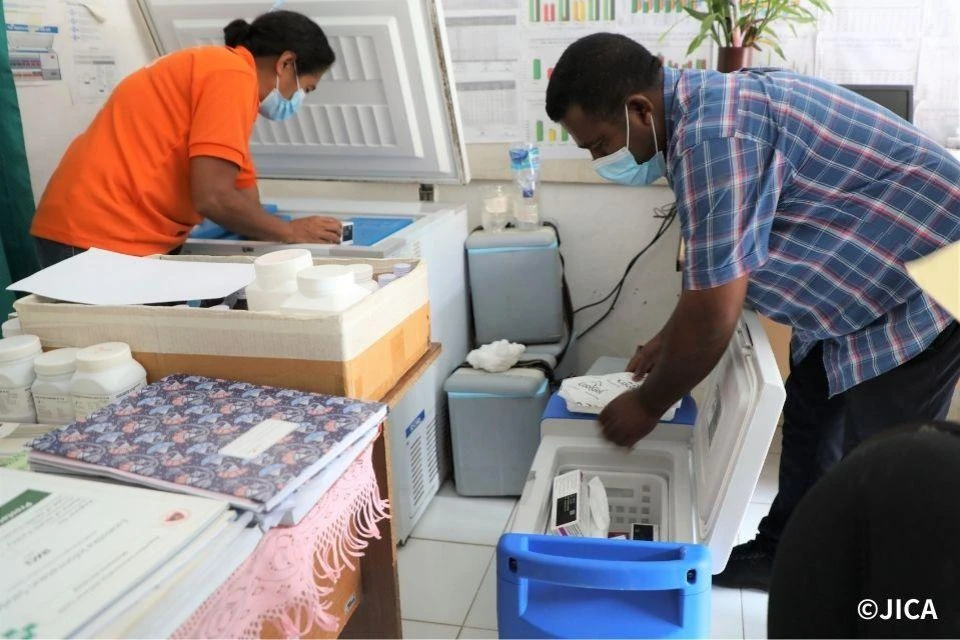 Image of medical staff at a vaccination center in Timor-Leste using a vaccine freezer equipped with a Free Piston Stirling Cooler