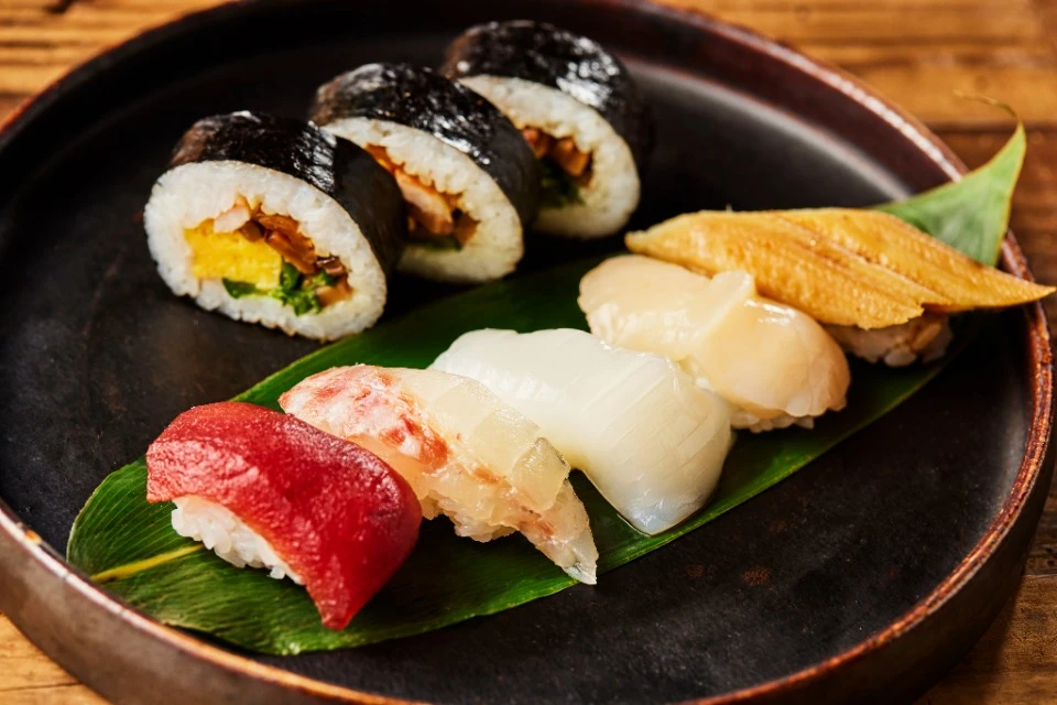 A variety of frozen then thawed nigiri and rolled sushi on a laquer platter