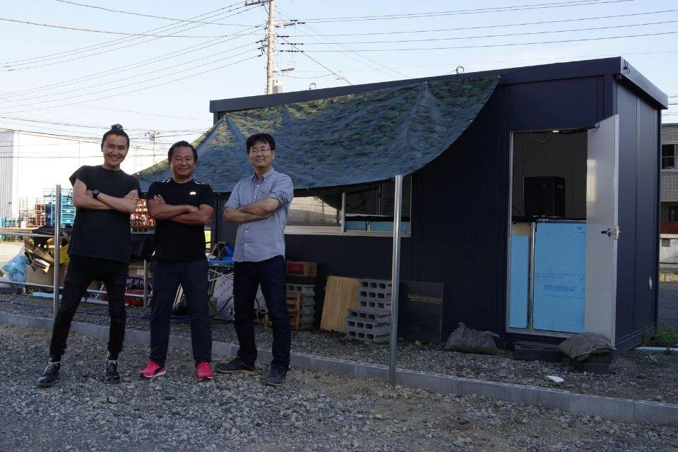 The co-founders of Ark Inc. in front of the first-generation Ark-V1, the predecessor of the Ark Zero.