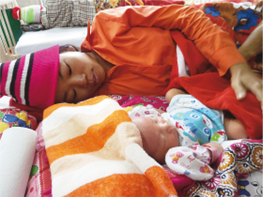 A mother with her baby after giving birth at the NMCHC. About 7,500 babies are born each year at this health center.